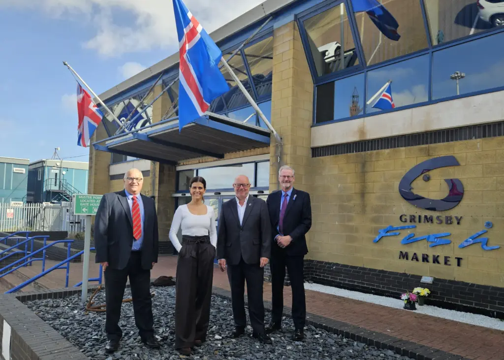 The group outside Grimsby Fish Market with the Union Jack and Icelandic flag flying above the entrance.